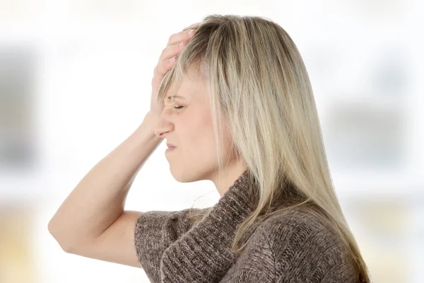 Frau mit Kopfschmerzen hält ihre Hand an den Kopf — Stockfoto