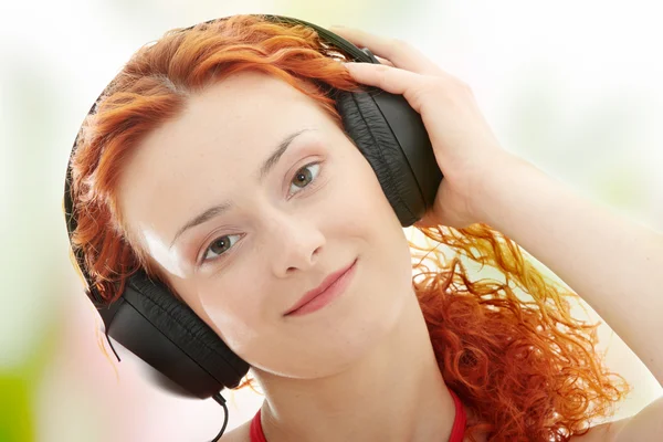 Rödhårig lyssnar musik — Stockfoto