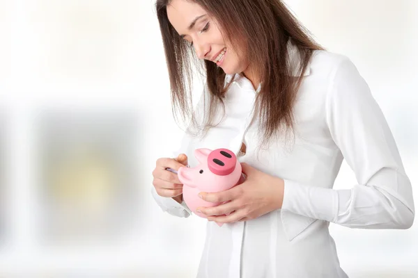 Young beautiful woman standing with piggy bank — Stock Photo, Image