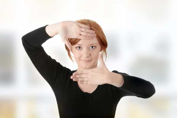Молодая привлекательная женщина обрамляет свои руки — стоковое фото