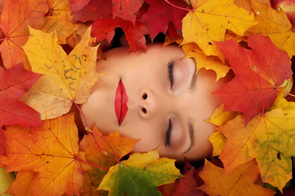 Ženská tvář na podzim listy — Stock fotografie