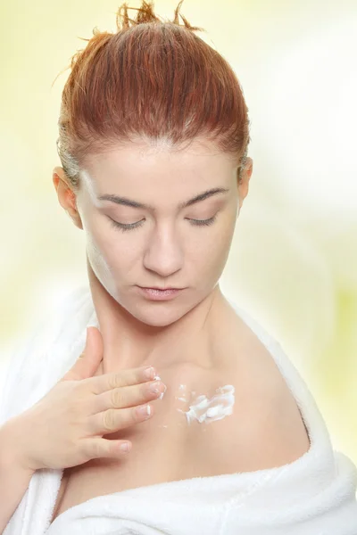 Mujer aplicando crema hidratante — Foto de Stock