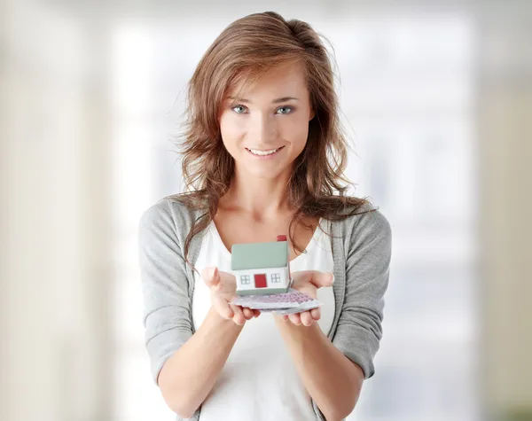 Mujer sosteniendo billetes de euros y modelo de casa — Foto de Stock