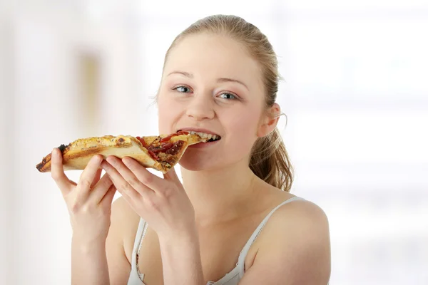 Ung kvinna äter pizza — Stockfoto