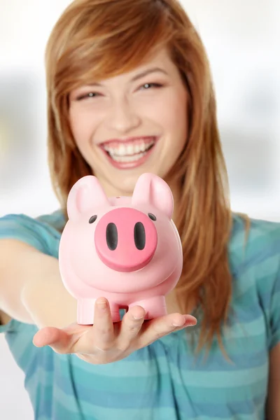Teenager-Frau zeigt ihr rosa Sparschwein — Stockfoto