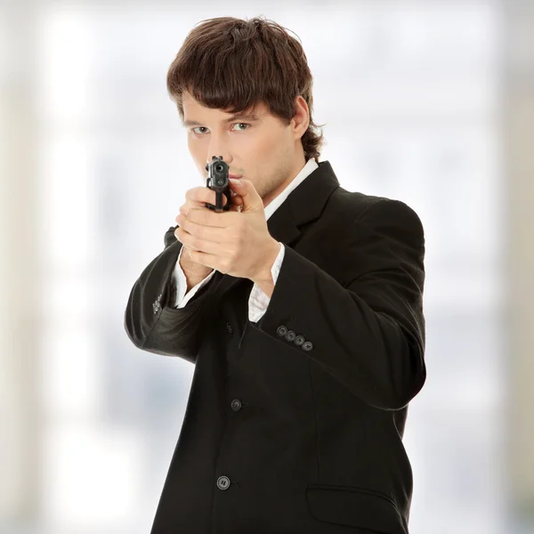 Forretningsmann med håndvåpen som mål – stockfoto
