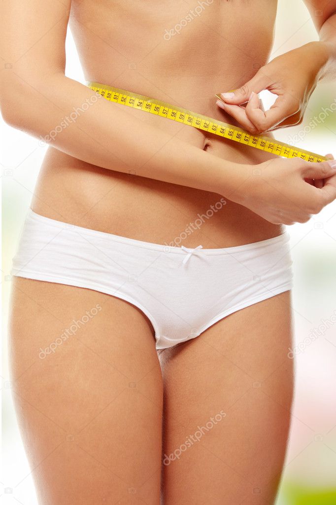 Young woman measuring her waist