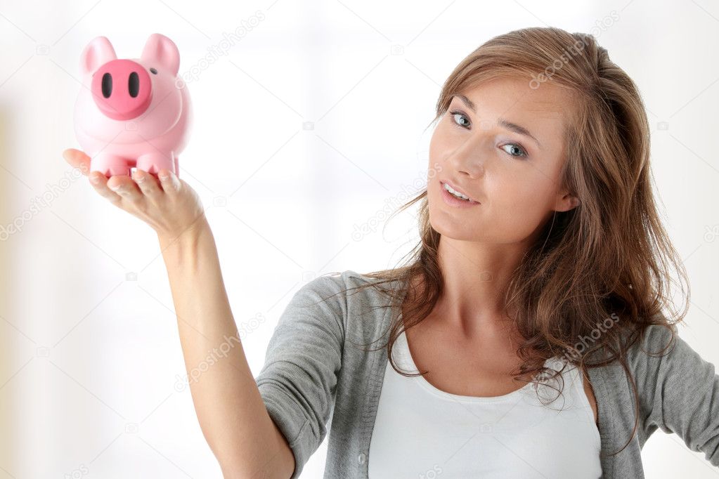 Young beautiful woman standing with piggy bank