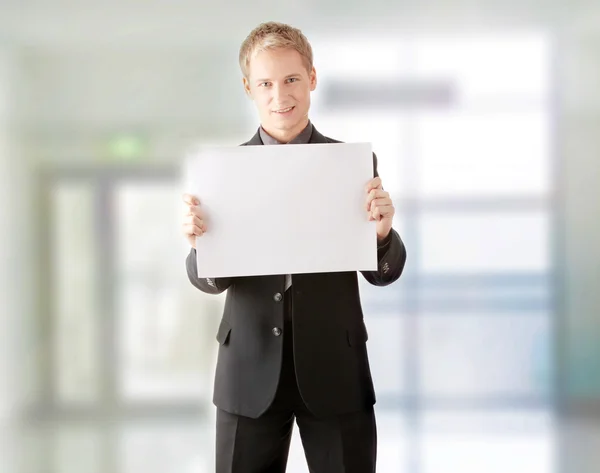 Young businessman holds blank signs. — Stock Photo, Image