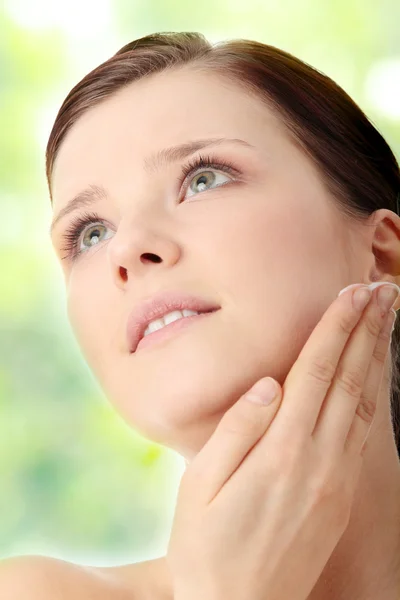 Vrouw toepassing moisturizer crème op gezicht — Stockfoto