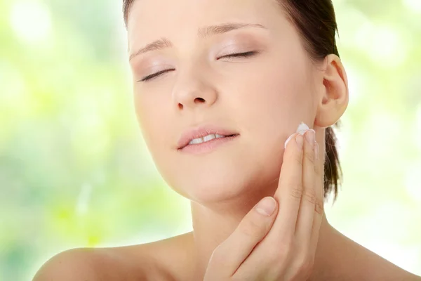 Woman applying moisturizer cream on face — Stock Photo, Image