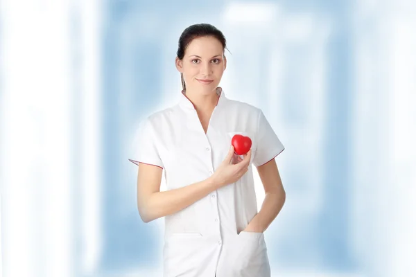 Jonge verpleegster met hart in haar hand — Stockfoto