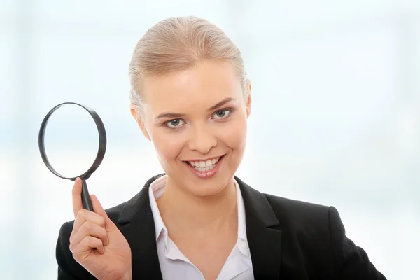 Business woman looking into a magnifying glass — Stock Photo, Image