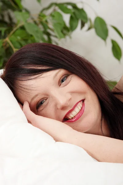 Jonge vrouw in bed — Stockfoto