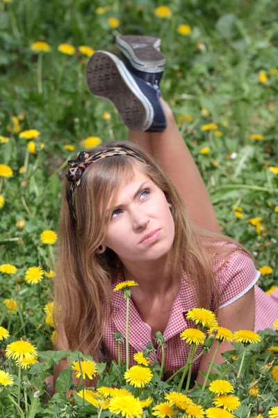 Güzel bir kadın çim ve çiçek rahatlatıcı — Stok fotoğraf
