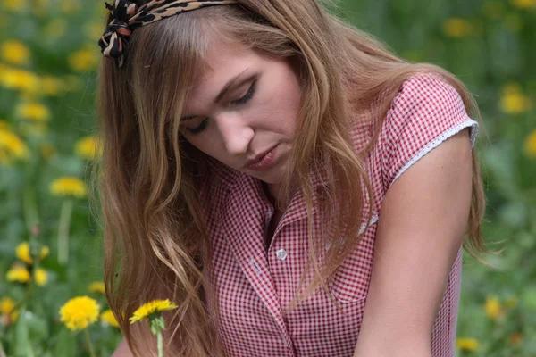 Mooie vrouw ontspannen in het gras en bloemen — Stockfoto