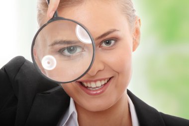 Business woman looking into a magnifying glass clipart