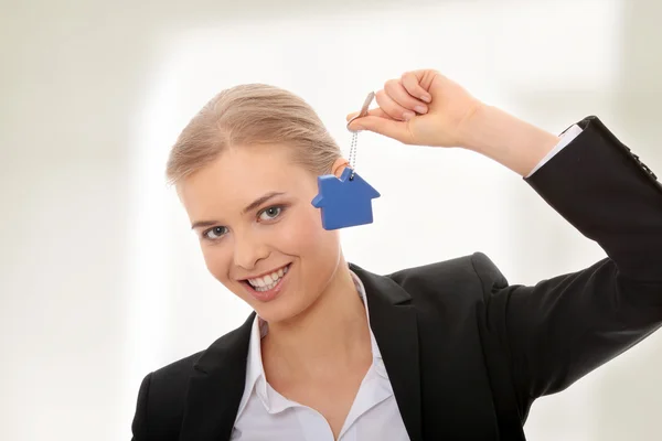 Young businesswoman holding house shaped key chain — Stock Photo, Image
