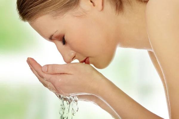 Jeune femme se lave le visage — Photo