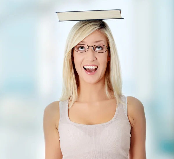 Student met boek op haar hoofd — Stockfoto