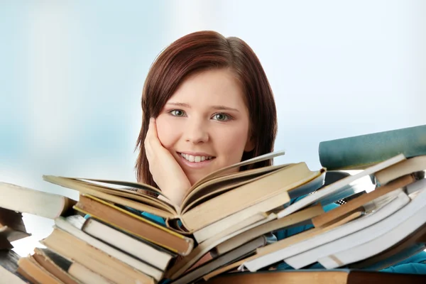 Mladá žena, sedící za knihy — Stock fotografie