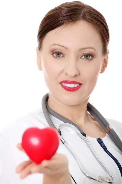 Mature female doctor with heart in her hand. — Stock Photo, Image
