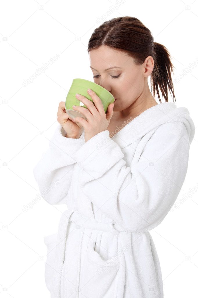 Mature lady in bathrobe drinking from mug