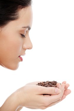 Woman holding asnd smelling coffee beans clipart