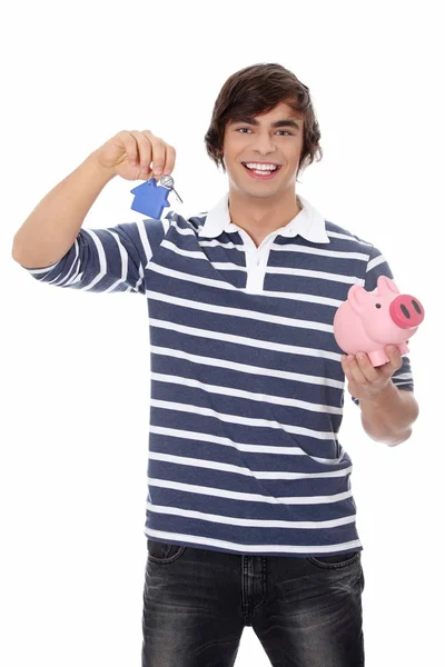 Junger Mann mit Schlüssel und Sparschwein. — Stockfoto