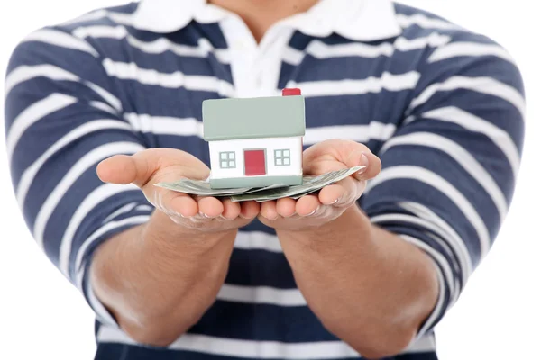 Young man with money and house's model. — Stock Photo, Image