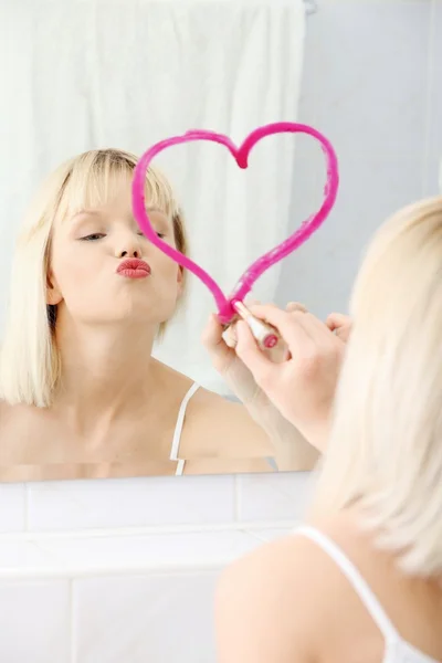 Joven hermosa mujer dibujando gran corazón en el espejo . —  Fotos de Stock