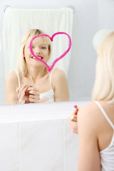 Giovane bella donna disegno grande cuore su specchio . — Foto Stock