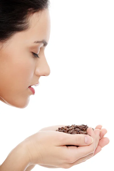Mujer sosteniendo asnd oliendo granos de café —  Fotos de Stock