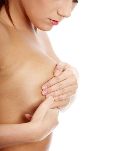 Jovem mulher adulta caucasiana examinando seu peito — Fotografia de Stock