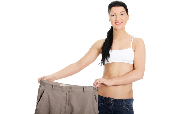 Joven mujer feliz mostrando cuánto peso perdió — Foto de Stock