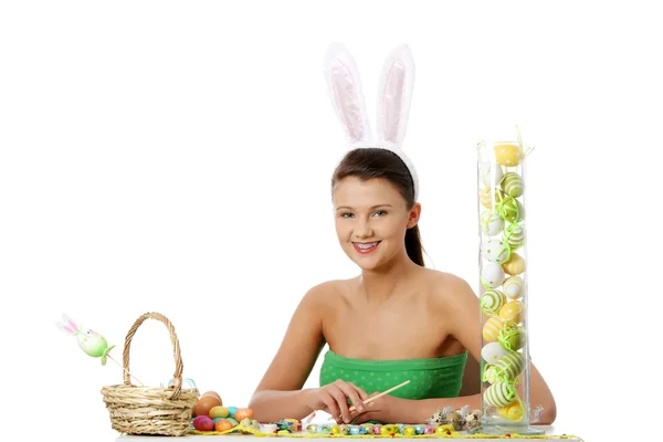 Ung flicka med bunny öron gör påsk dekoration — Stockfoto