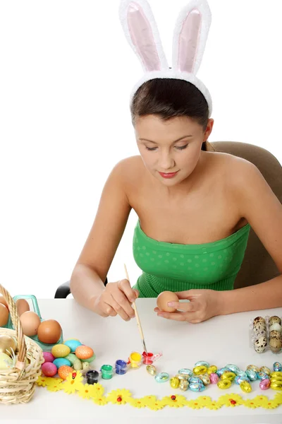 Young girl with bunny ears is making easter decoration — Stock Photo, Image