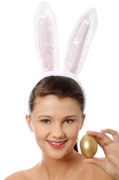 Young girl with bunny ears holding golden egg — Stock Photo, Image