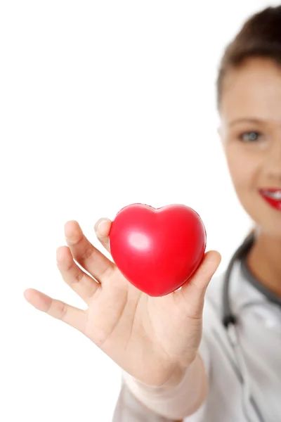 Young female doctor with heart in her hand. — Stock Photo, Image