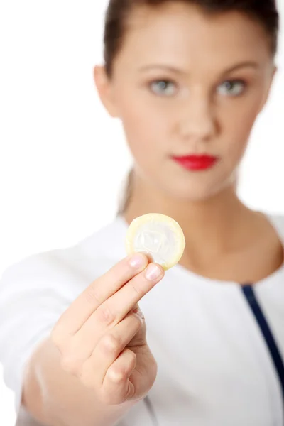 Female doctor holding condom — Stock Photo, Image