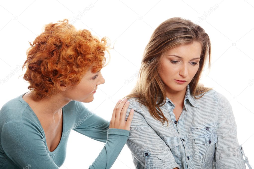 Troubled young girl comforted by her friend