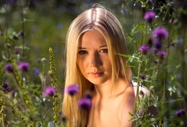 野生花卉之间美丽的年轻女孩的肖像 — 图库照片