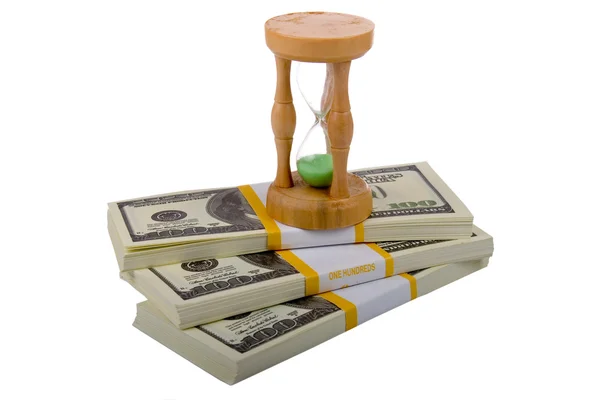 Hourglass on a packs of dollars — Stock Photo, Image