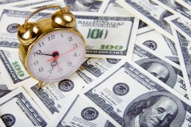 çalar saat dolar yığını üzerinde