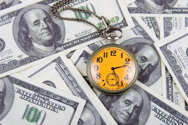 Reloj de bolsillo en una pila de dólares — Foto de Stock