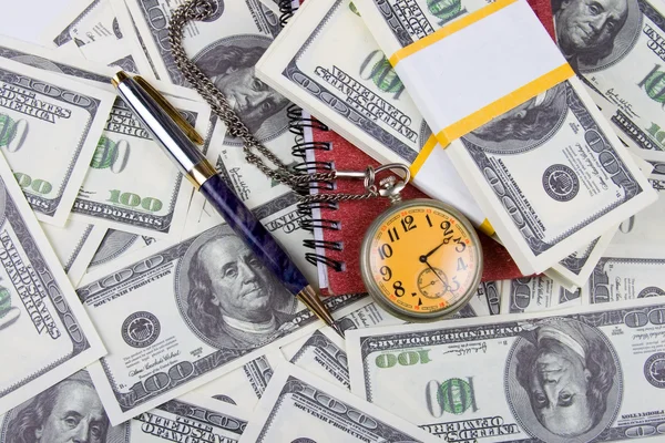 Ρολόι τσέπης, σημειωματάριο και στυλό πάνω σε μια στοίβα δολάρια — Φωτογραφία Αρχείου
