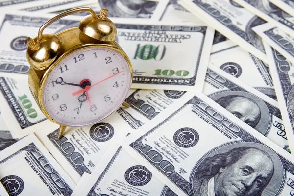 Alarm clock on a stack of dollars — Stock Photo, Image