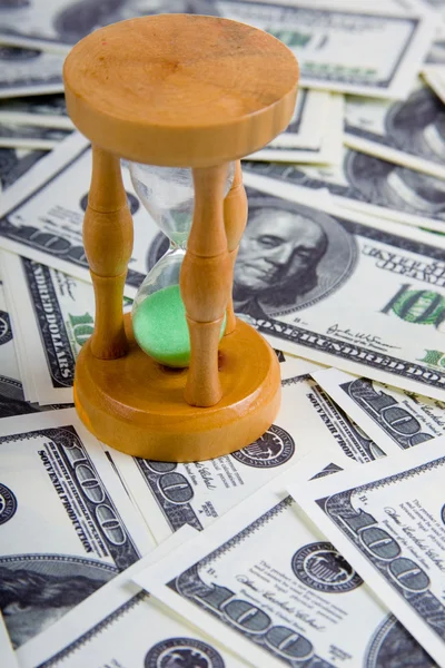 Sandglass on a stack of dollars — Stock Photo, Image