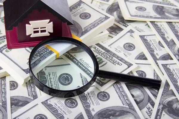 House and magnifying glass of one hundred dollar bills background — Stock Photo, Image