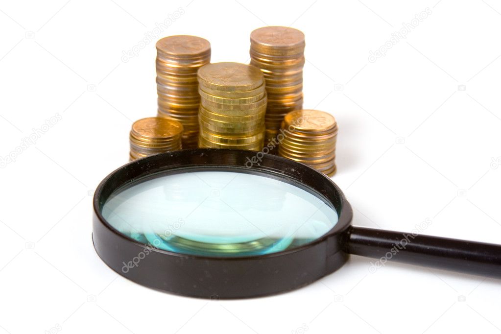 Piles of gold coins and magnifying glass